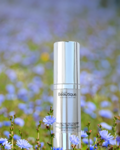 Lifestyle image of Tri-Biome Recovery Concentrate serum in a field of purple flowers