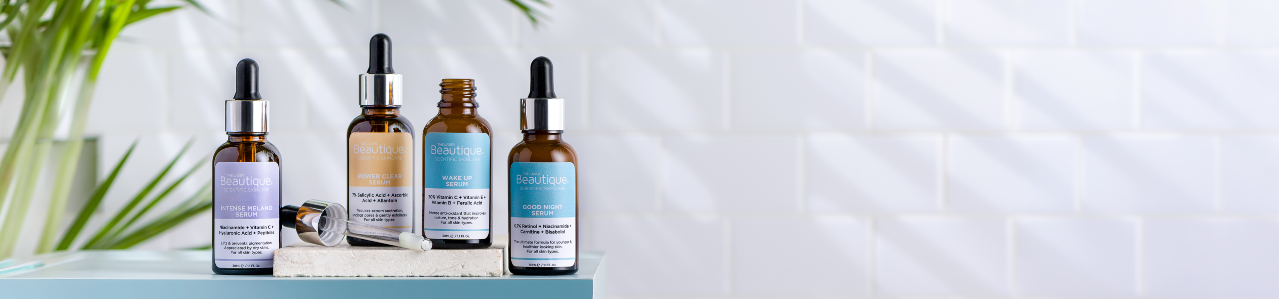 The Laser Beautqiue's Scientific Skincare Serums on a luxurious bathroom counter with a summary green leaf in the background